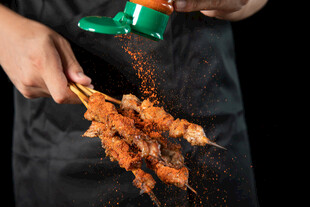 厨师撒料制作美味烤肉串