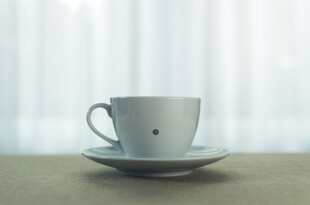 简约白杯置于浅色桌面上