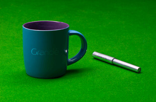 绿色背景下的杯子与笔