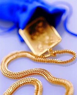 精美金项链与蓝色布袋