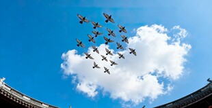 编队战机飞过古建筑上空