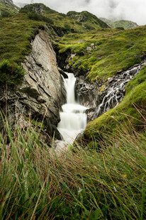 山间瀑布下的葱郁草地