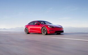 红色轿车行驶在开阔道路上