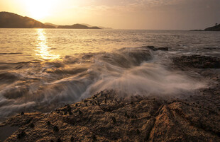 夕阳下海浪拍岸的美景