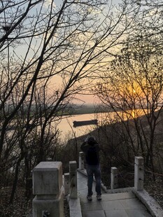 黄昏湖畔步道上的漫步身影