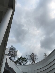 弧形建筑下的天空与树木
