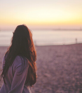 海边独赏日落的长发女子