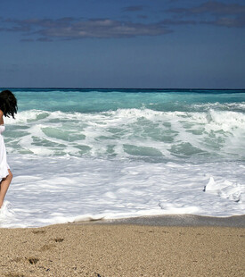女子于海边沙滩漫步赏景
