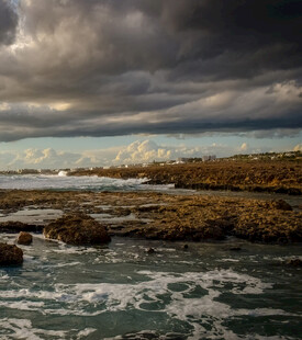 海边乌云下的礁石与海浪