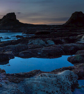 黄昏下的岩石与静谧水洼