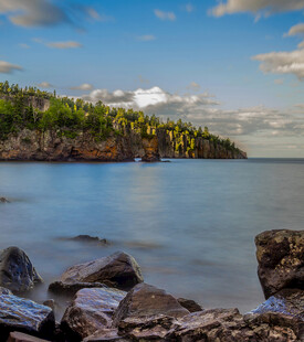 湖畔岩石与葱郁树林美景