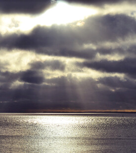 海上破晓阳光穿透云层