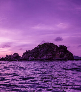 紫色霞光中的海中岩石