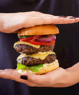 双手捧起的多层美味汉堡