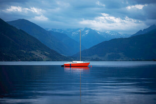 湖面上的红色帆船与山峦