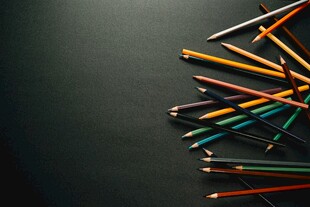 彩色铅笔堆叠在深色背景上