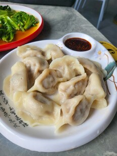 美味饺子配蘸料与蔬菜