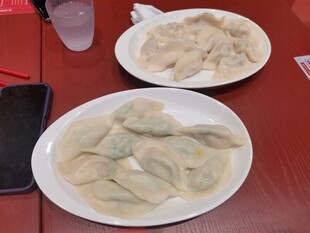 两盘美味饺子摆于桌