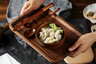 手持木盘享美味饺子