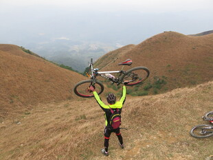 山地骑行者高举爱车