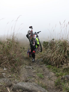 徒步者在雾中穿行山间小道