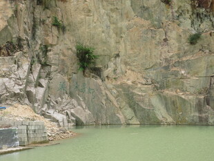 山间绿水旁的陡峭岩壁