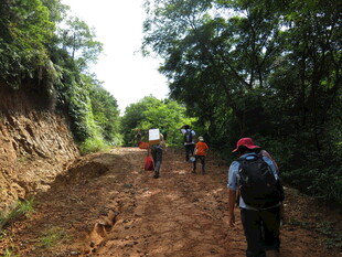 徒步者穿行于山间泥路