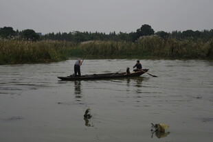 河上小舟三人悠然划船