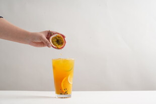 手挤百香果入杯鲜榨果汁