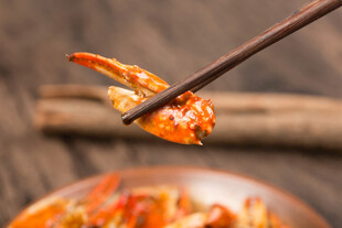筷子夹起美味香辣蟹钳