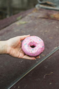 手持粉色甜甜圈特写