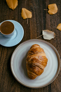 木质桌上的咖啡与牛角包