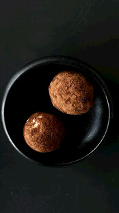 黑盘里的两颗可可粉圆球