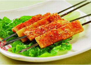 美味烤肉串摆于生菜上