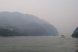 江上雾景中的船只与山峦