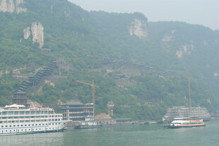 江景中的巍峨山峦与游船