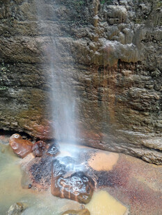 恩施山间瀑布下的多彩岩石景观