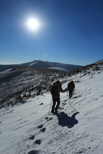 雪地徒步者沐浴阳光前行