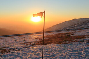 雪地日出中的飘扬旗帜
