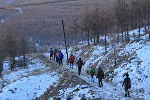 雪地徒步者攀登山间小道