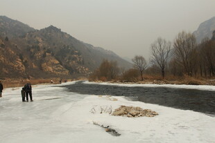 冬日河畔雪景中的行人