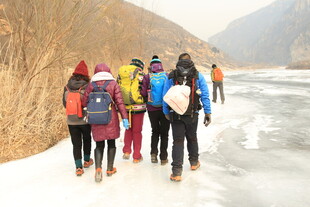 徒步旅行者在冰雪山间前行