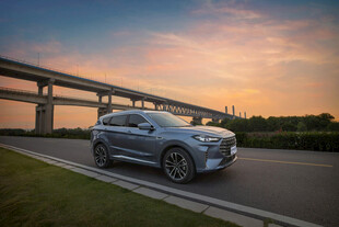 夕阳下公路上行驶的SUV