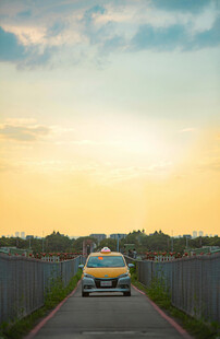 夕阳下公路上的黄色赛车