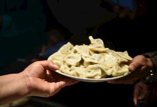 双手端着一盘饺子