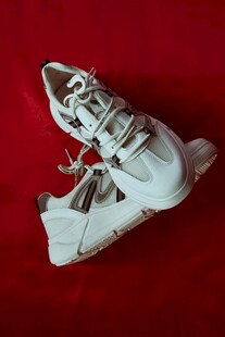 白色运动鞋置于红色背景