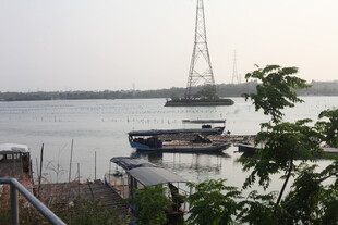 湛江河畔船只与远处高塔景观