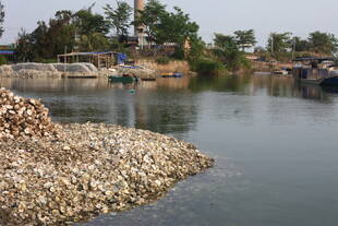 湛江河边堆积的沙石与建筑场景