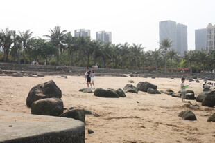 湛江沙滩上的大石与远处建筑