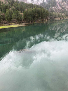 宁静碧绿湖水与山林倒影
